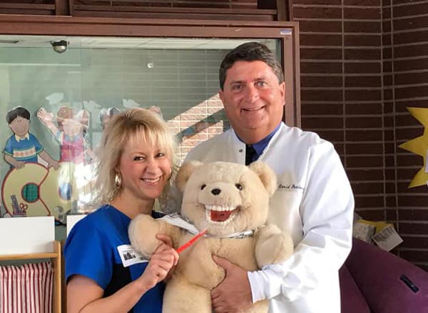 Dr. David Paulussen and a dental assistant with a bear used to teach proper dental hygiene in Hackettstown, NJ