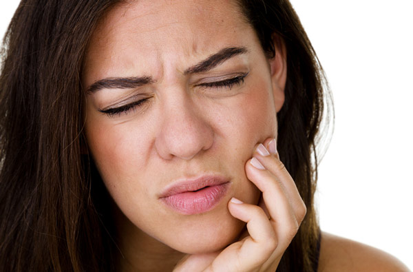Woman holding jaw due to TMJ pain in Hackettstown