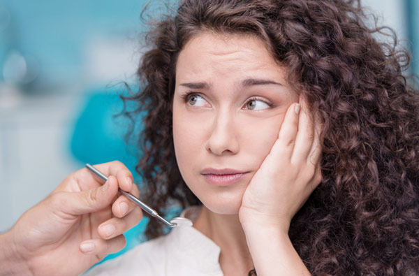 Hackettstown woman holding cheek due to tooth ache